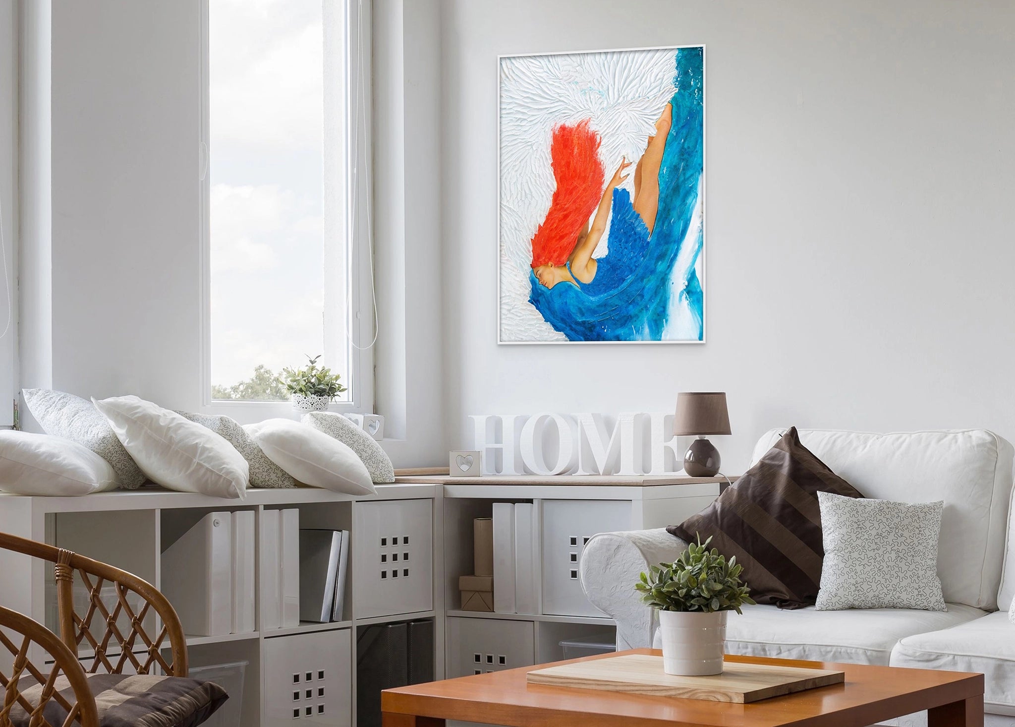 Hue the Artist framed canvas print of a red haired woman diving into blue and white ocean. It hangs in a cosy light filled room with white furniture and cushions.