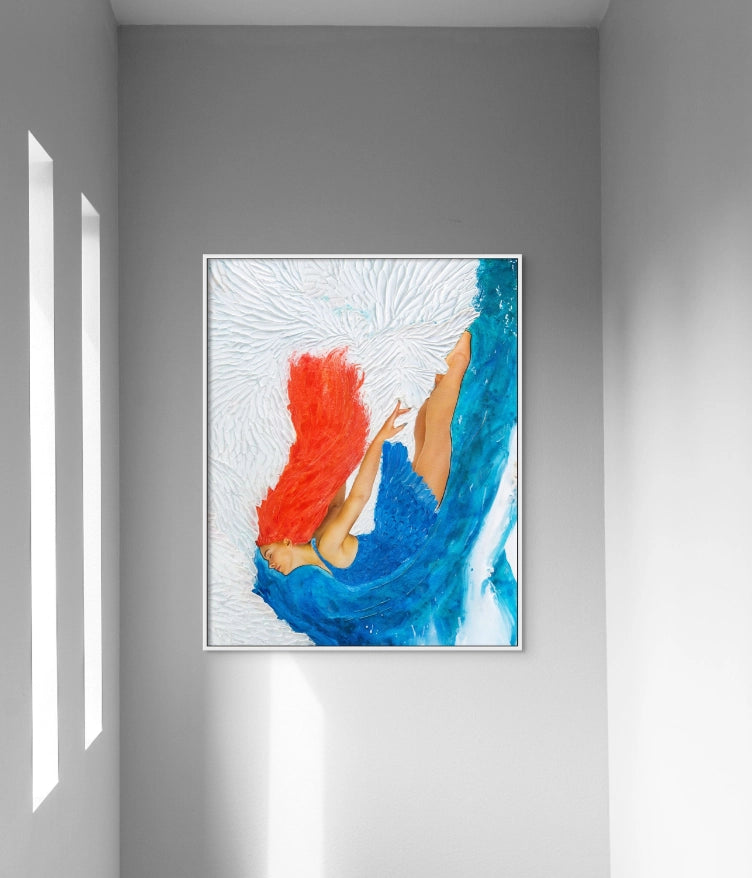 Framed artwork of a red-haired woman diving into a blue and white ocean hangs in a tall stairwell with light streaming through three narrow windows.