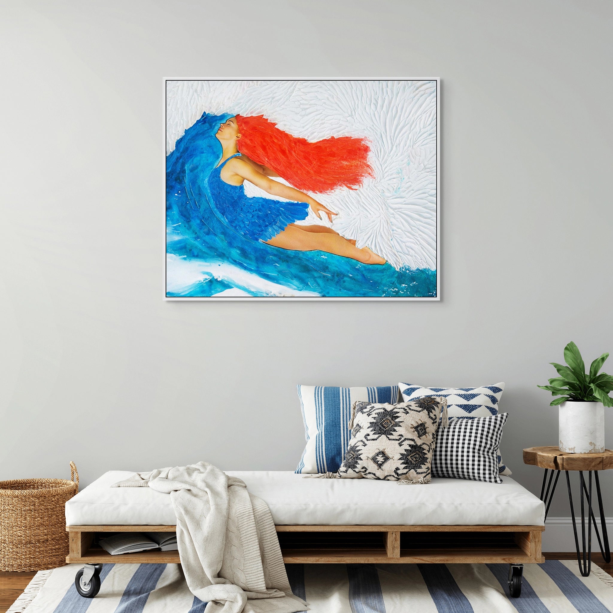 Framed Hue the Artist canvas print of a red haired woman flying into blue and white sky. It hangs in a room with blue and white decor and a coastal vibe.